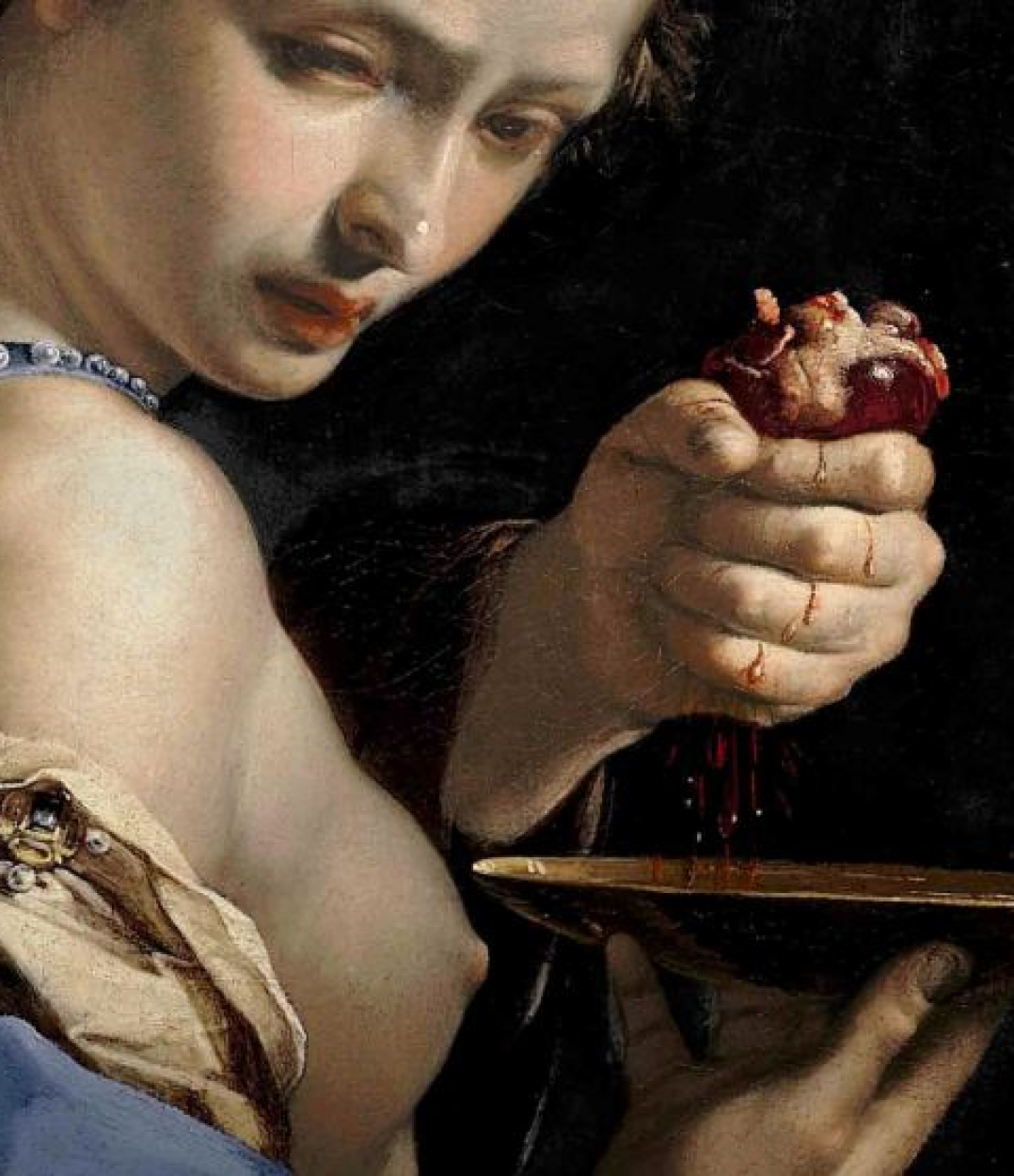 portrait of woman holding a human heart looking forlorn